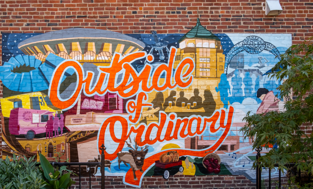 An image of a mural in downtown Champaign that says "Outside of Ordinary"