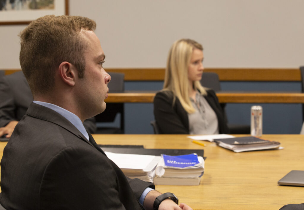 A male and female student sit in a classroom.