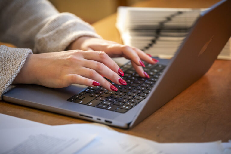 Student typing on a laptop computer.