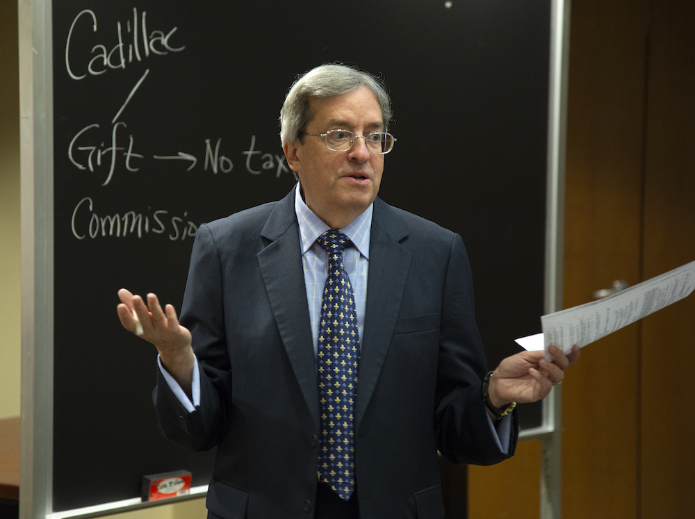 Professor Kaplan teaches in front of a blackboard