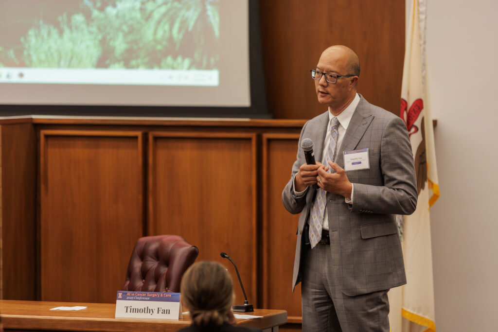 Timothy Fan, a presenter at the AI in Cancer Surgery and Care Conference, holds a microphone and speaks