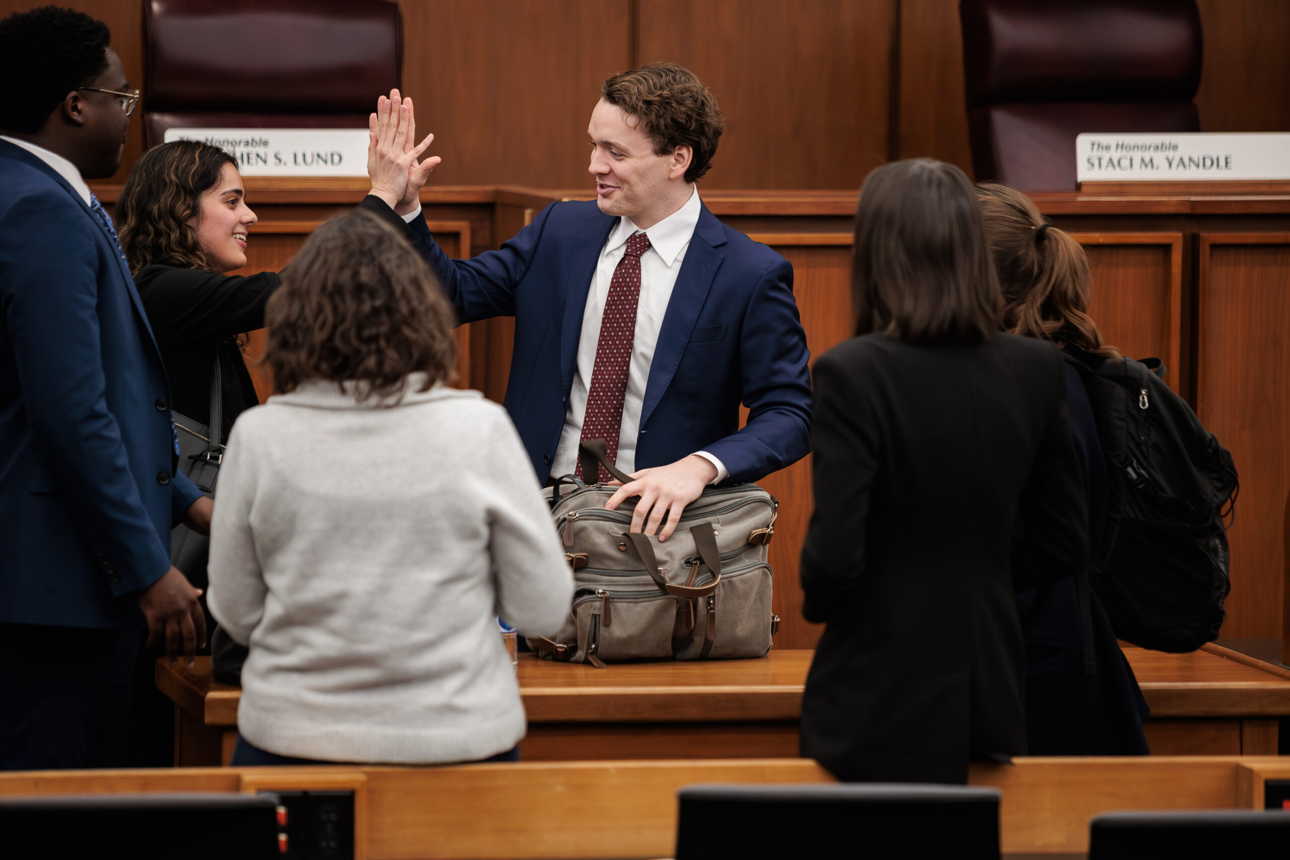 A female student gives a male student a high five before a moot court competition