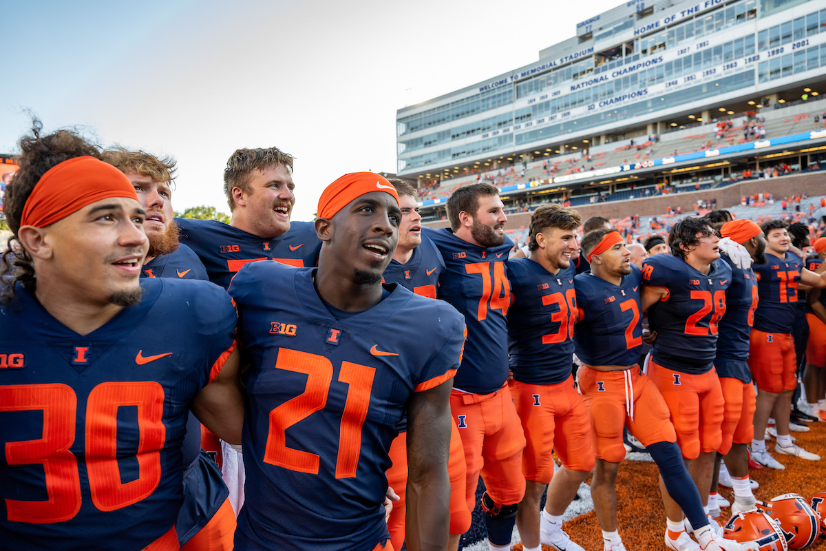 The Fighting Illini Football team gather in the end zone to sing the school song with fans.