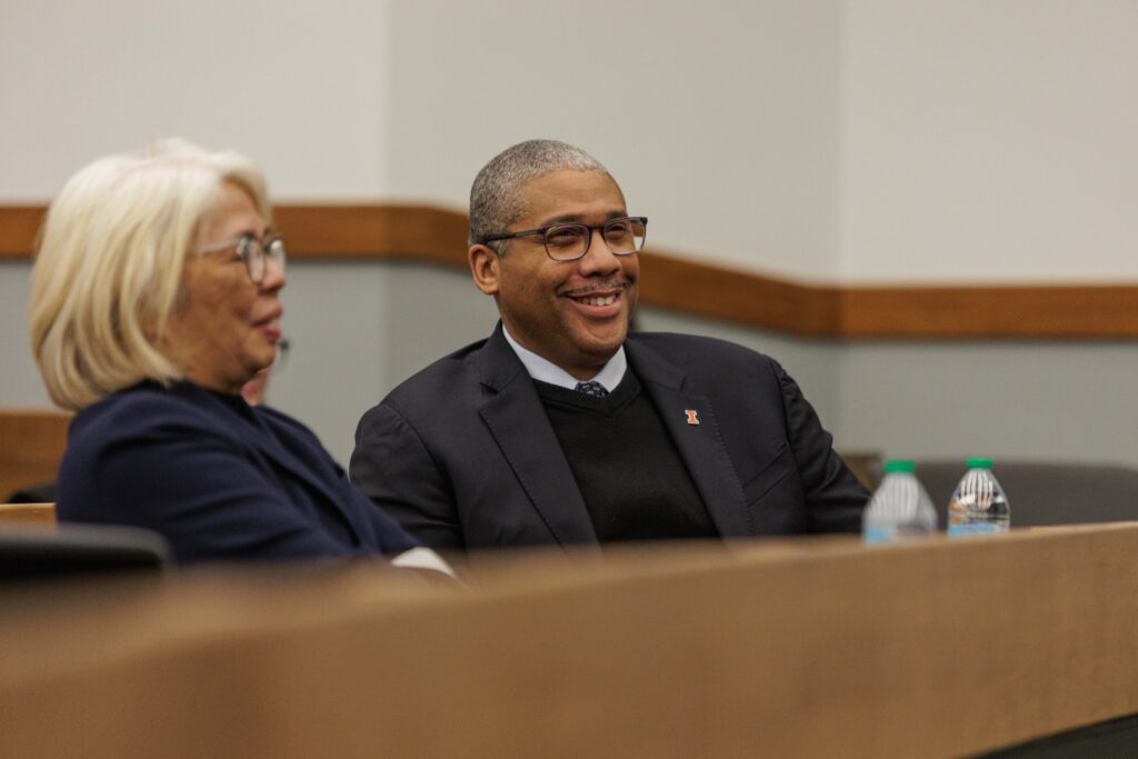 Amy Santos and Jamelle Sharpe talk and laugh together in a classroom