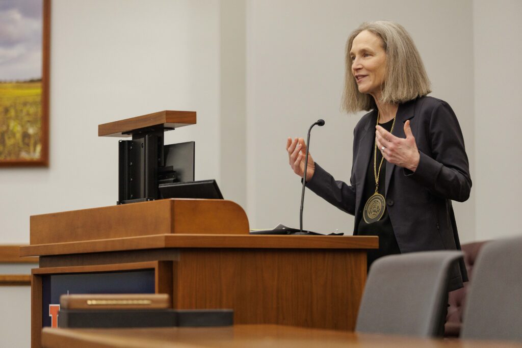 Verity Winship speaks at a podium during her investiture ceremony.
