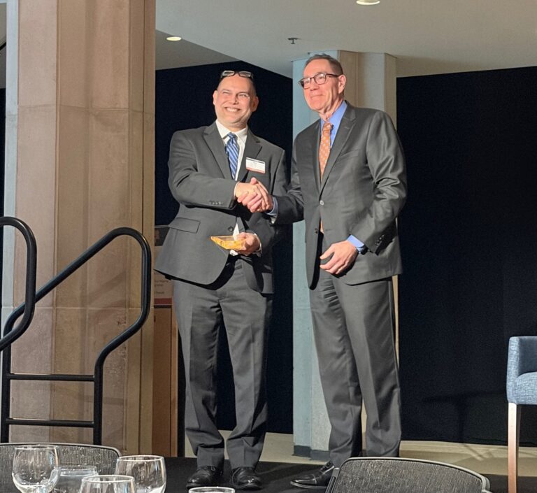 Rob Kar shakes hands with Provost Coleman during an awards ceremony.