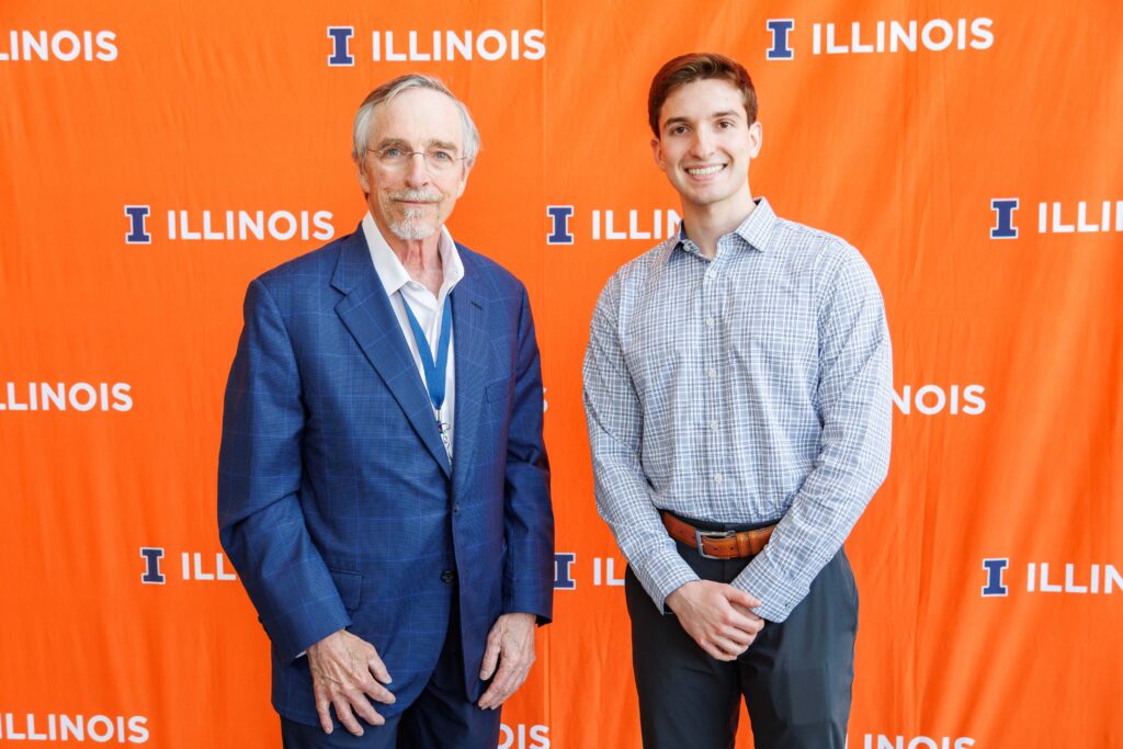 A male scholarship donor and a male student scholarship recipient pose for a photo together during the annual scholarship luncheon.