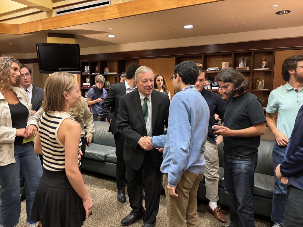 Students shake hands with Senator Dick Durbin during a lecture.
