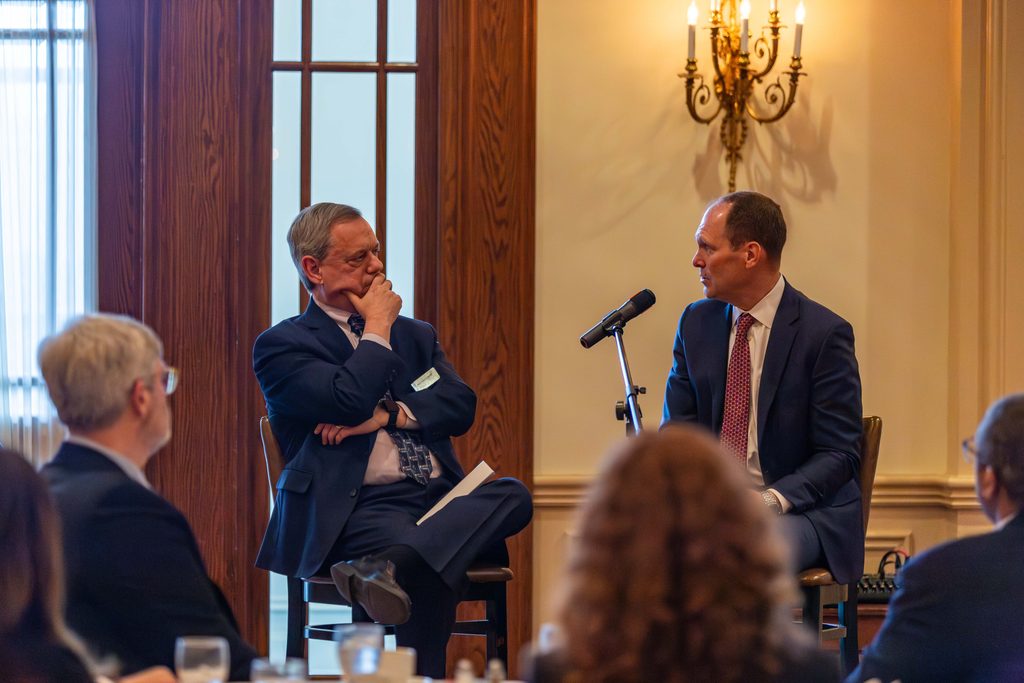 Professor Andy Leipold engages in conversation with Judge Thomas Kirsch during a luncheon in the judge's honor.
